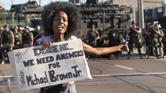 A protester shouts as she moves away from a line of riot police, Ferguson MO, 8/13/14